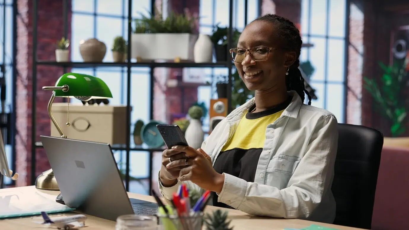 Портрет радостного человека, читающего сообщения на мобильном телефоне.